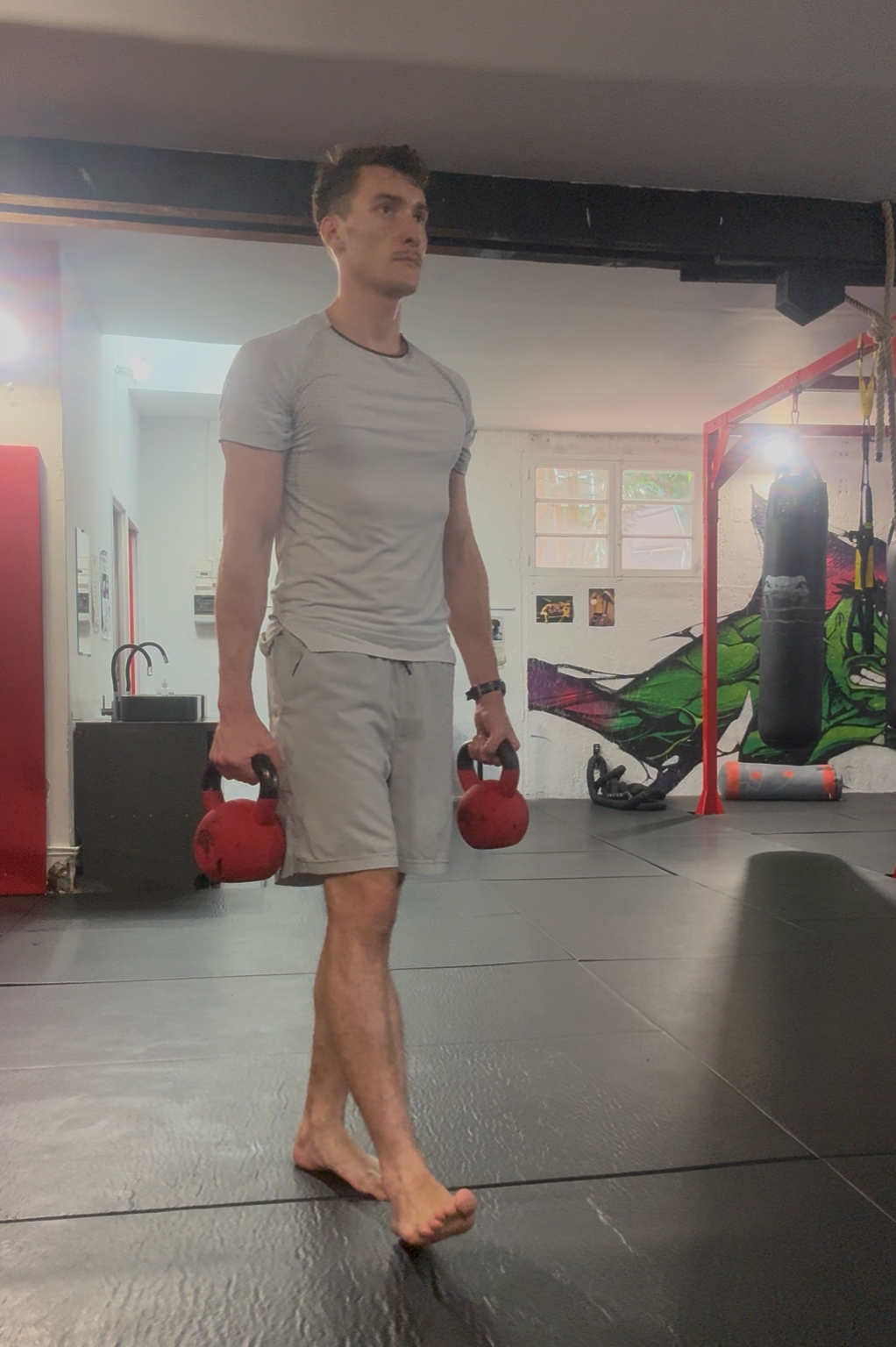 Port de charge : marche avec une kettlebell dans chaque main, buste gainé