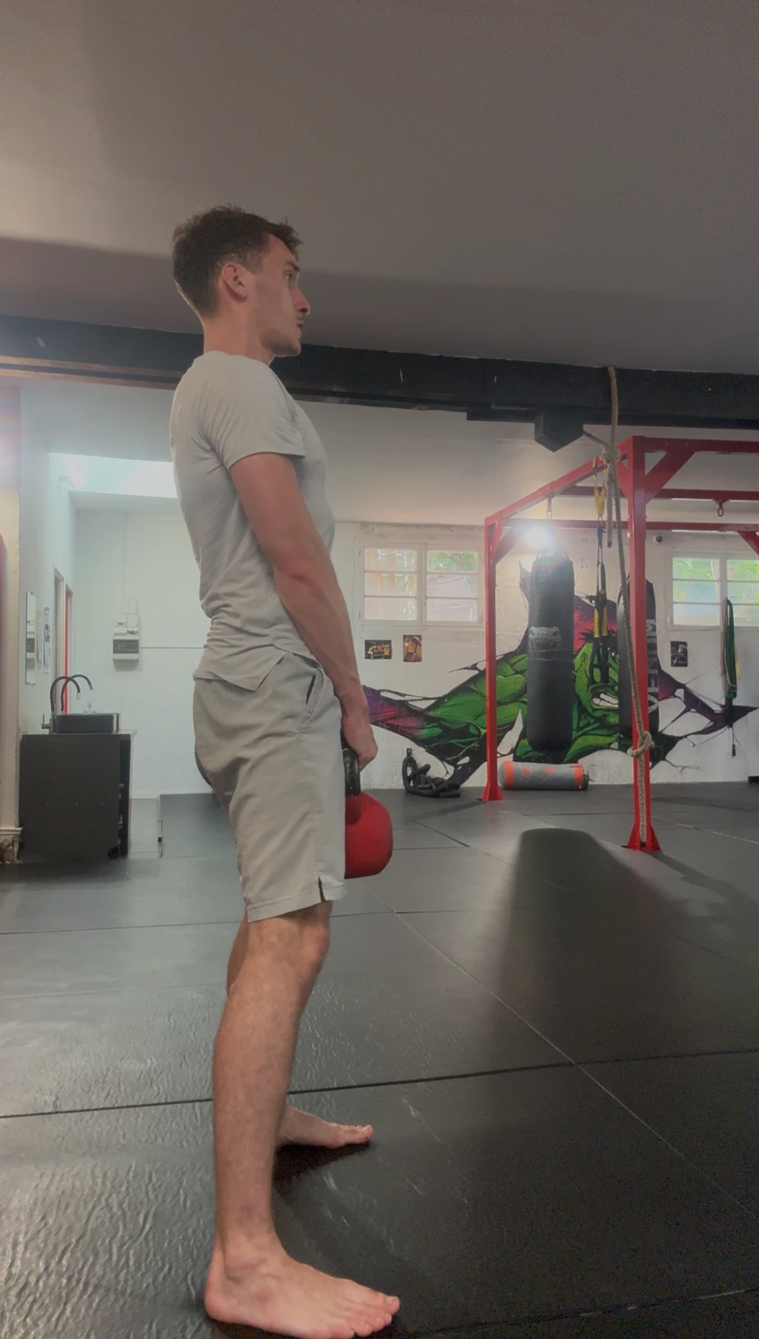 Charnière de hanche : position haute, buste redressé, kettlebell tenue à bout de bras